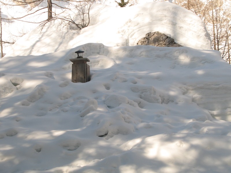 Hiška GRS na Okrešlju pod debelo snežno odejo, dimnik opozarja, da se nekaj dogaja v notra