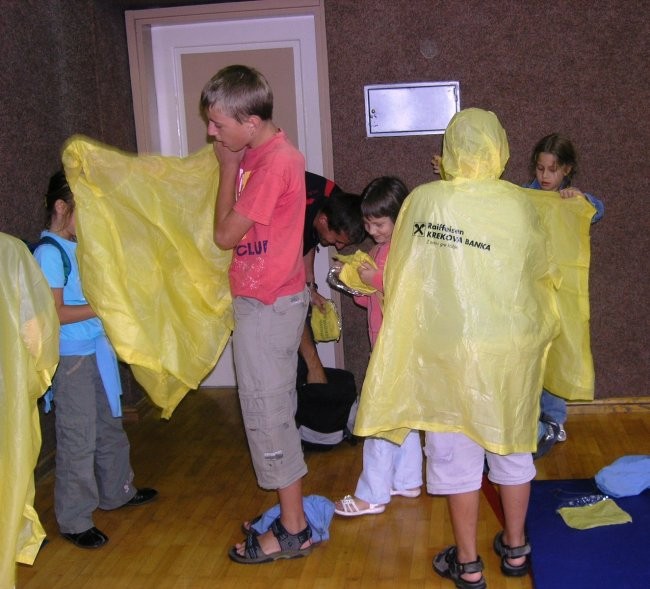 Pred odhodom na kosilo so se otroci zaščitili pred dežjem.